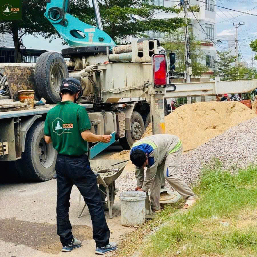 Công nhân đang sử dụng máy và công cụ thi công để đổ sàn mái tầng 1 tại nhà chị T.
